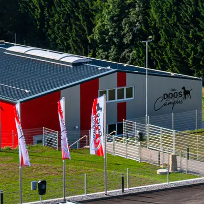 Außenansicht der Trainingshalle Granit eingezäunten Wiesenflächen am Campusgelände